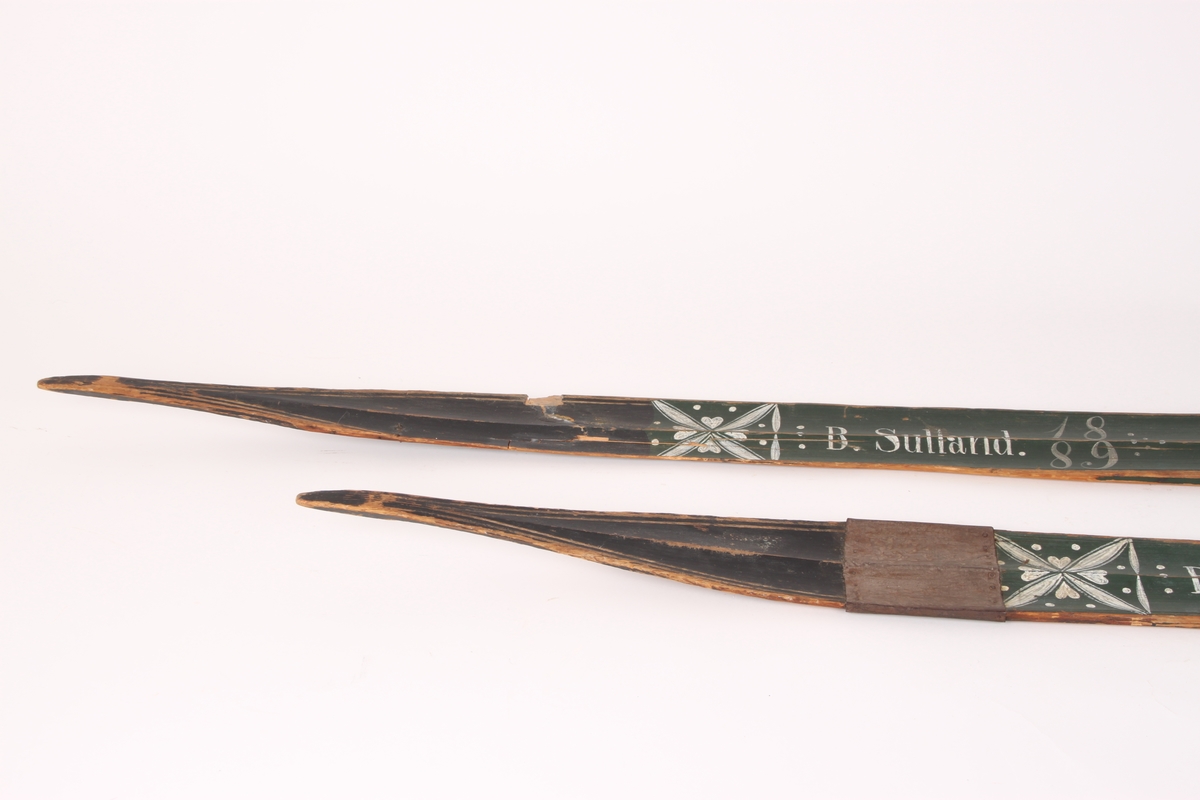 Et par treski i helved med lang og smal tupp, flat overside og fortykning under. Avsmalnende framski og jevnbred bakski og møneformet rygg langs hele skiens lengde. Dekoren er fra Krødsherad med fremre del av framskien malt i svart, og med rosett og navn med årstall i hvitt. Rosett også på skienes bakende. Skiene har tåstropp av vidje og har sannsynligvis hatt ilkebinding. Bindingshullene har innskjæring med skråsnitt på skienes sider. Skiene er rett avskåret bak. Ingen rand under.