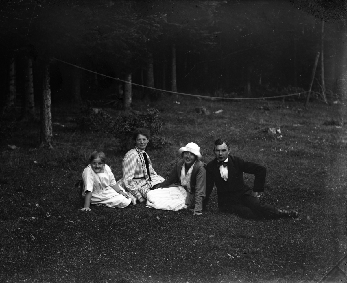 En flicka, två kvinnor och en man sitter i gräset. De är från vänster Birgit, hennes farmor Berta, faster Karin och Gustaf Bolling.