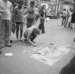En gjeng som er samlet og spiller og synger på en åpen plass