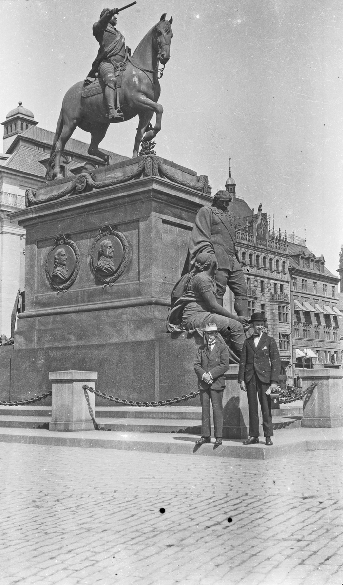 To menn som har stillt seg opp foran en stor statue av en mann til hest. Hverdagsfoto.