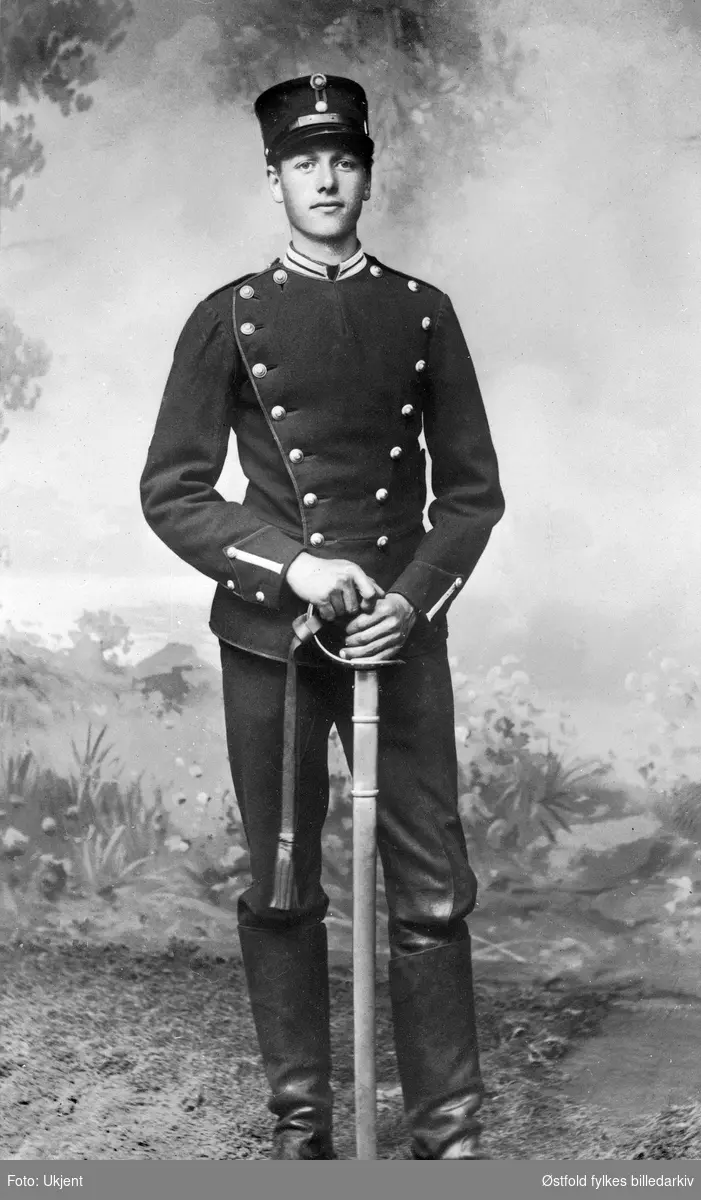 Skolelev Olaf Syversen ved kavalleriets under-offisersskole i skoleuniform i 1918. Han red en kvarter-hest Lom fra Torkildsrud i Eidsberg. Syversen bodde på gårde Jakobshaugen 45/1-3 i Skiptvet.