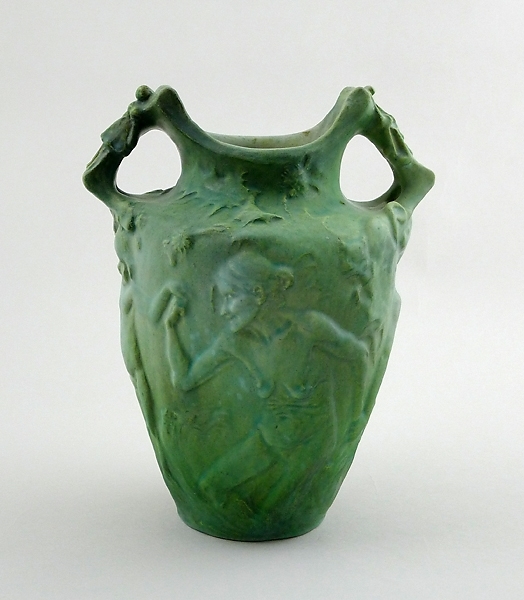 Urnformad vas med två handtag; grönpatinerad. På utsidan dekorerad med nakna figurer i olika åldrar.
Enl. liggaren föreställande de fyra åldrarna.

Märkt "de Frumerie. Scp teur". I botten "Lachenal  ceramiste"