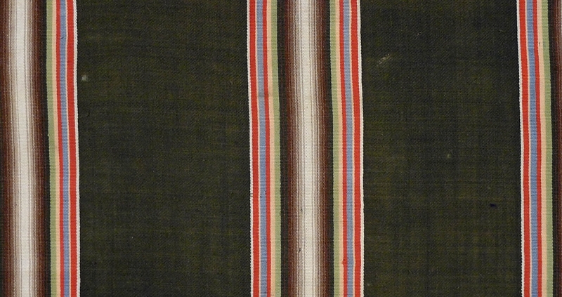 Enl. liggare:
"Schal, svart med ränder i ett flertal färger av ylle. St. 150 x 145 cm

1887

tillhört hennes (givarens) morfar och mormor, "fästmögåva", se brev