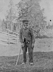 Mann, klær, skigard, stokk.