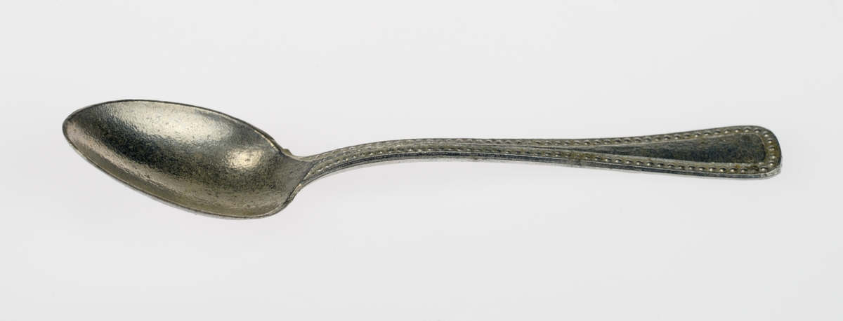 En liten bestikkurv med lekebestikk i. Alt er laget av metall. Gjenstandene er undernummerert 01-08, på de minste gjenstandene står kun undernummeret da det ikke var plass til hele FTT-nummeret.
FTT.54449.01: En trådkurv laget av blå metallnetting som er falset sammen med blankt metall. Bestikkurven har tre rom.
FTT.54449.02-03: To kniver med bredt blad og avrundet i enden. Skaftet har prikkmønster langs kanten og en opphøyet stripe i midten.
FTT.54449.04-05: To gafler med lik utforming men av ulik størrelse. Begge har fire tenner. På skaftet er det prikkmønster langs kanten og en opphøyet stripe på midten.
FTT.54449.006-07: To identiske skjeer. På skaftet er det prikkmønster langs kanten og en opphøyet stripe på midten.
FTT.54449.08: En liten øse med rundt hode. Skaftet er rundt før det blir flatt i enden. I endene er det også krokformet (for oppheng).