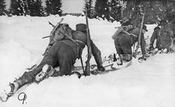 Menn, uniform, gevær, ski og skistaver, naturforhold. 
Frem