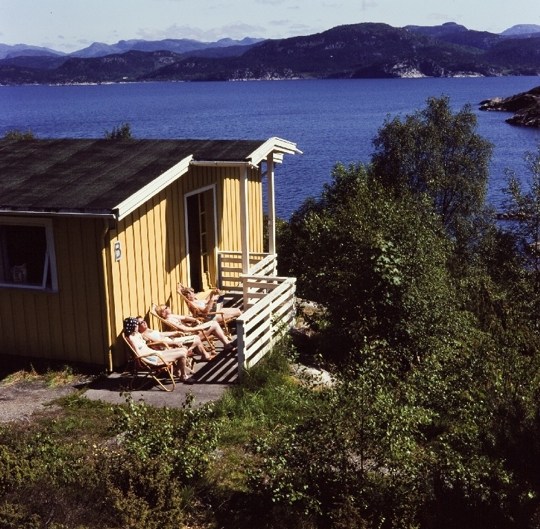 Solende personer utenfor feriehjemmet nr. 5 til bedriften Jonas Øglænd Sandnes på Bersagel