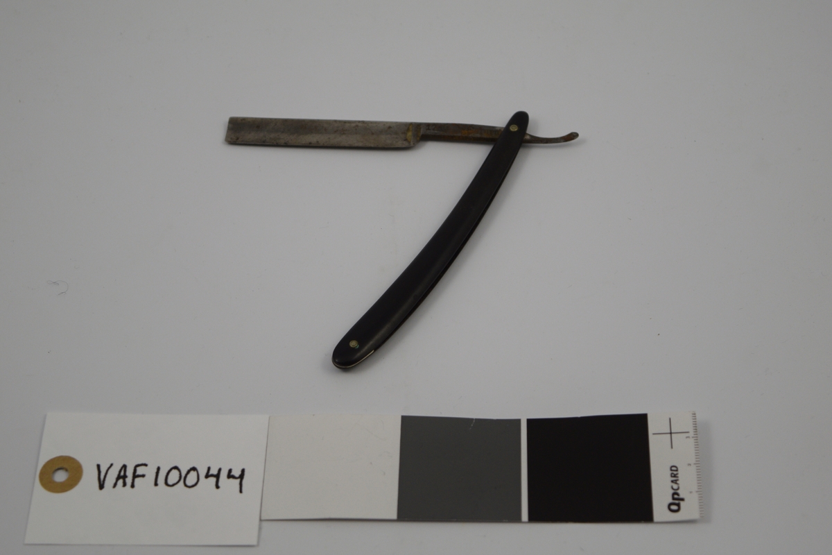 Sammenleggbar barberkniv med rett egg. Bladet munner ut i tynt skaft
med en krumning som holdegrep med fingeren. Skaftet er naglet fast til
kniven. Består av to deler, der den ene delen fungerer som beskyttelse for 
kniven i sammenlagt stilling.