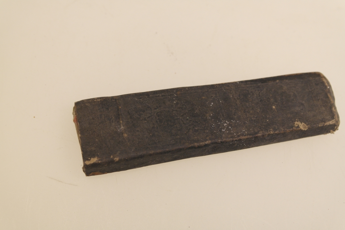 Barberkniv (A) med futeral (B). 
A) Barberkniv med skaft i bein og blad i støpt stål. Bladet kan foldes inn i skaftet.
B) Futeral i svart papp. Innpreget harlekinmønster på den ene siden, og bladranker (?) på den andre siden.
Innpreging i bladet.