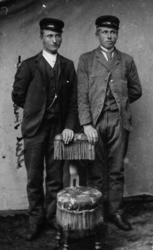 To menn står ved en stol.
Jens Jakobsen, Valvåg og Allert (