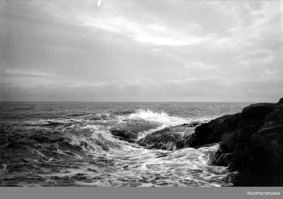 Foto fra sjøen, med bølger som slår inn over svabergene. Datering usikker. Fra Nordmøre museums fotosamlinger, Myren-arkivet.
