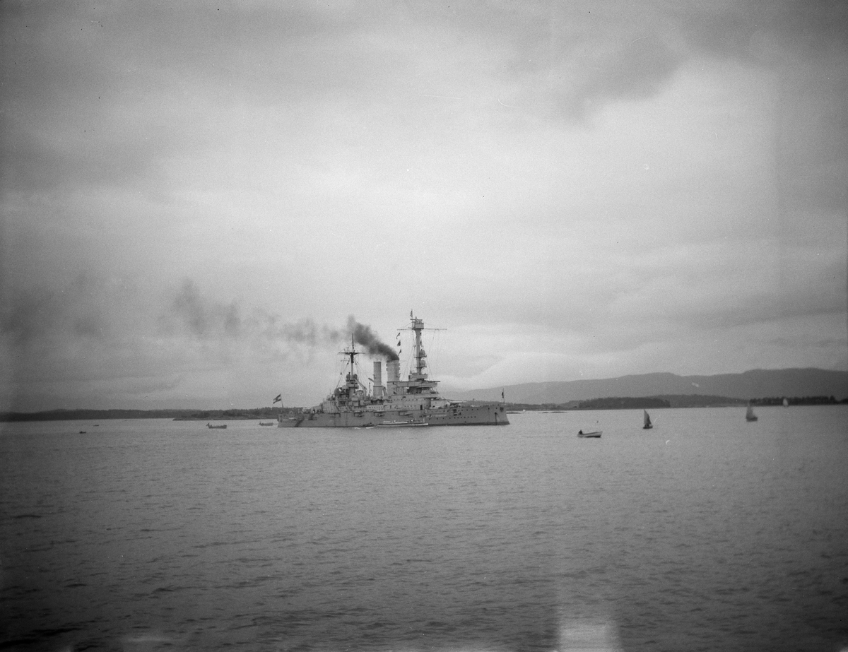 Det tyske marinefartøyet "Schlesien" på en fjord. Småbåter