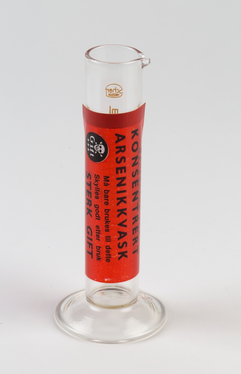 Målesylinder med gradering 5-25 ml, pålimt rød etikett.