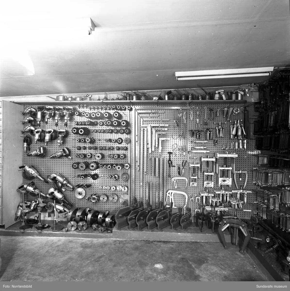 Interiörbilder från Näslund & Viklunds Järn på Sjögatan 19, med verktyg, maskiner, beslag och köksattiraljer.