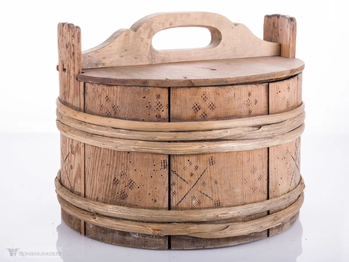 Lagget ambar med ører og lokk med hanke. Omslått med gjorder oppe og nede.