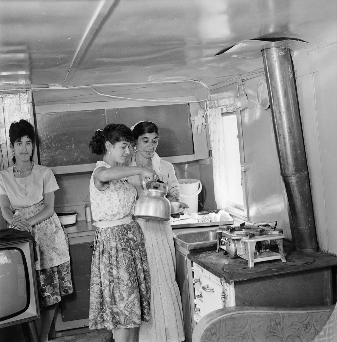 Margit Taikon får en kopp kaffe av sin dotter Marianne, i en bostadsvagn i utkanten av Uppsala, 1961