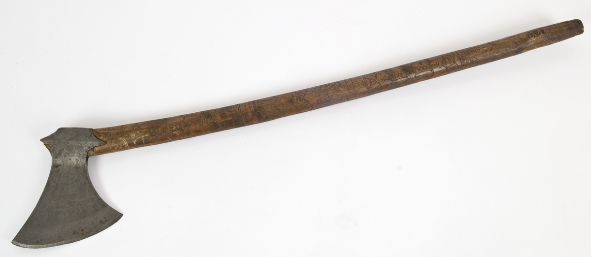 Asymmetrisk blad med lang øvre spiss og kortere nedre spiss.
Bladet er tynt, med påsmidd noe tykkere egg.
Øksehammeren har skaftehull og fliker.
Smedmerke formet som et skjell. Øksen har etset rankedekor på begge sider.
Skaftet er svakt krummet. Skaftet er merket på ryggen SON ANO 1700.Skaftet har skåret dekor i felter.