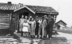 Mennesker foran bolighus på Midt-Øyen, Folldal