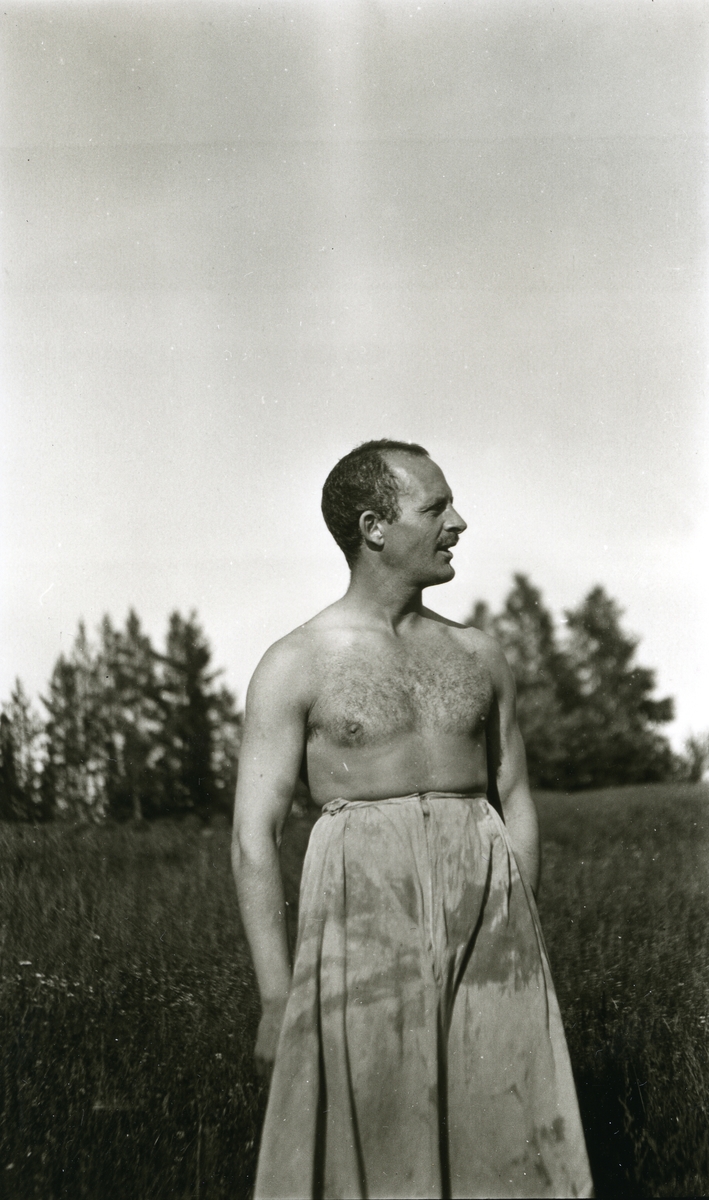 Mann, Haakon Garaasen (6/7 1887 - 1957) m/bar overkropp stående i eng ved Horrmundsjøen i Dalarne, Sverige.