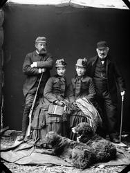 Gruppebilde. To kvinner sittende med en mann på hver side. M