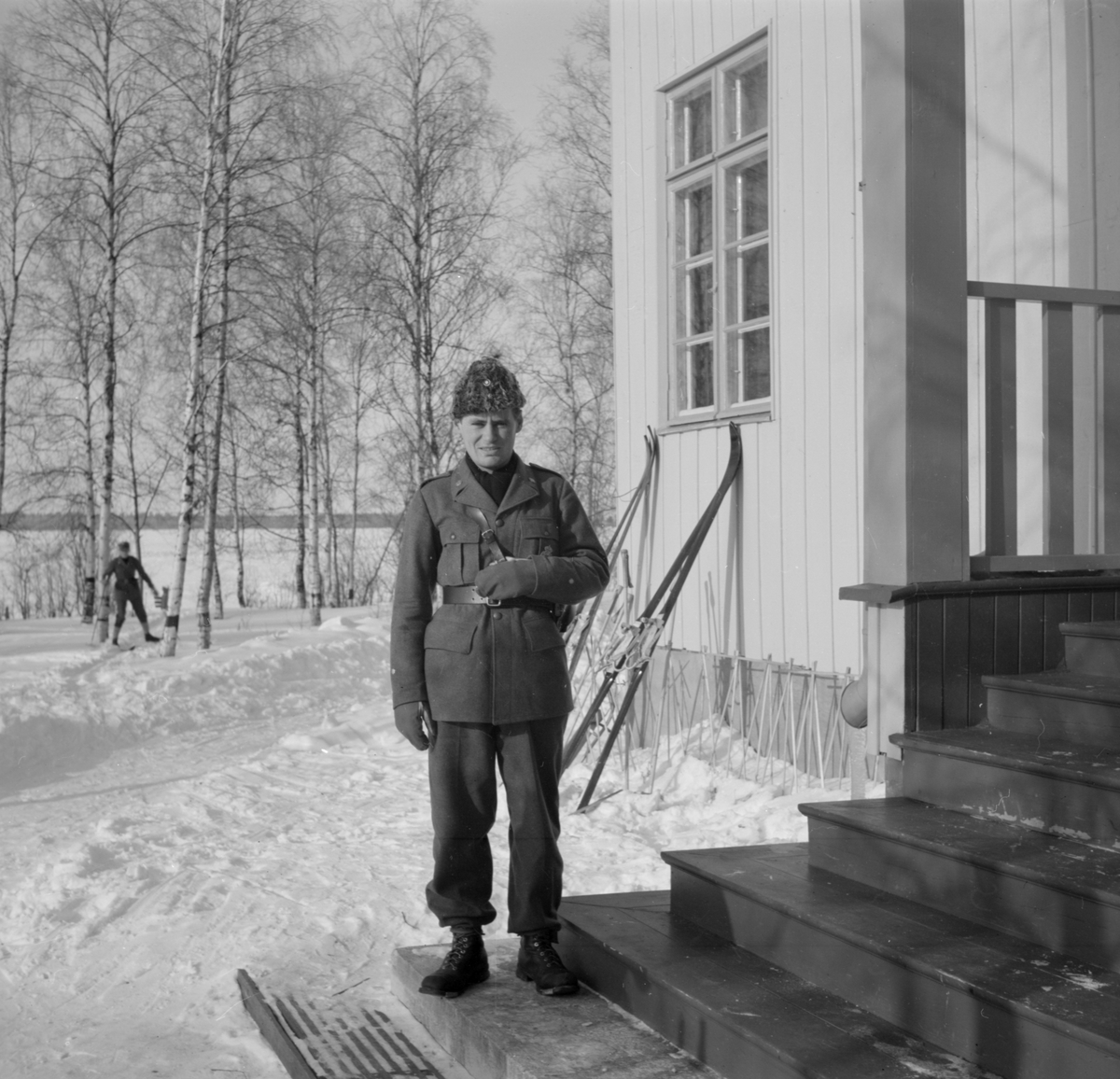 Porträttfoto av militär tillhörande Svenska frivilligkåren i Finland, F 19. Stående på trappa.
