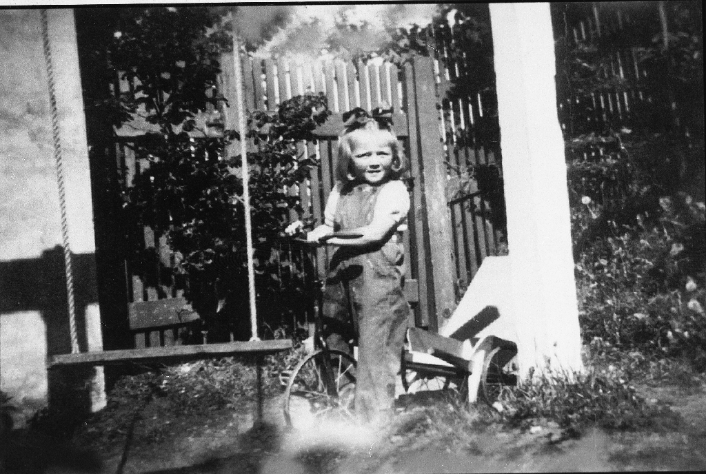 Bjørg Marit Auestad g. Bjørnevik (16.4.1945 - ) på trehjulsykkel i hagen hos Olav Garborg (10.8.1892 - 28.1.1964 )