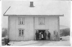 Prestkvern gård ca 1900. Familie, fem personer står ved inng