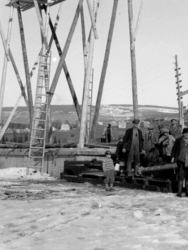 Byggingen av Vingnesbrua. Arbeidsstokken samlet på vannpumpa