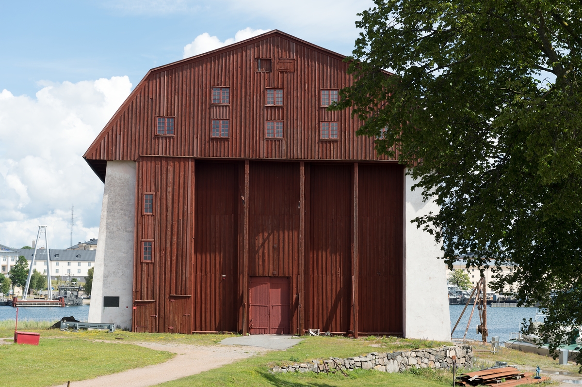 Fotodokumentation av byggnader på Lindholmen i Karlskrona. Stora skeppsskjulet uppfördes på 1760-talet och benämdes senare (1778) som Vasa skjul. Byggnaden fungerade som klimatskydd över stapelbädden. Ritningar av byggnaden från 1759 är signerade av arkitekt C J Cronstedt.
