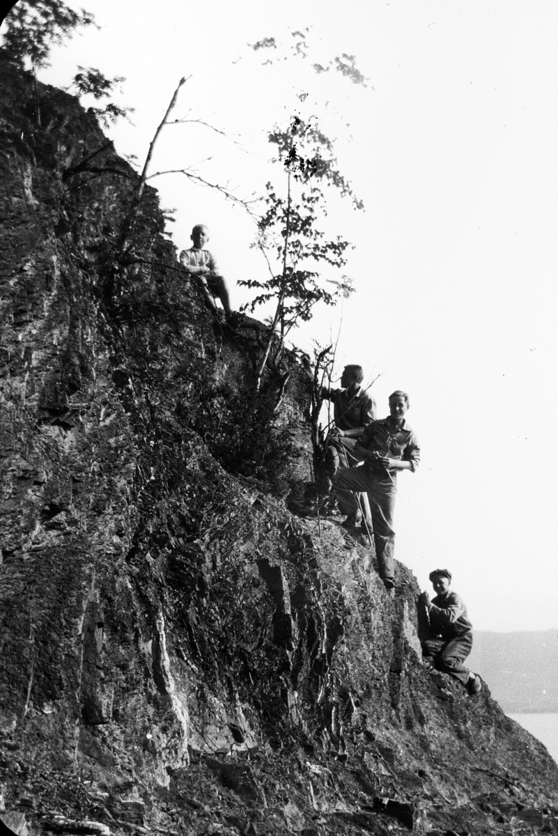 Gutter fra Toftes Gave, Nedre Sund, Helgøya klatrer i berget på Hovinsholmen.