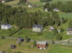 Tretten, Øyer. Stor toetasjes, gråmalt hus med hvite vindusk
