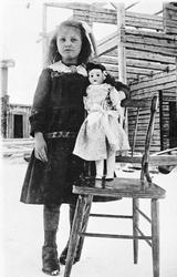 Ei ung jente med dokke på en stol. 
Liv Langøien