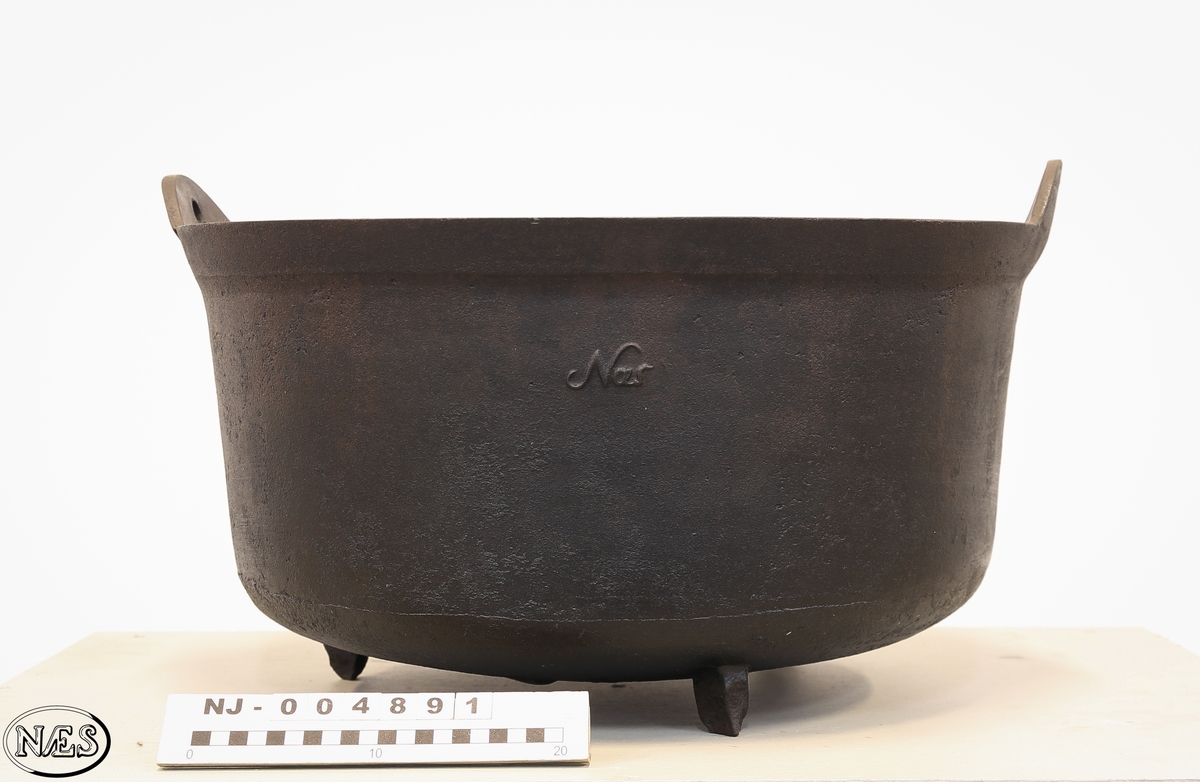 Rund jerngryte med tre bein og to ører på øvre kant for feste av hank.