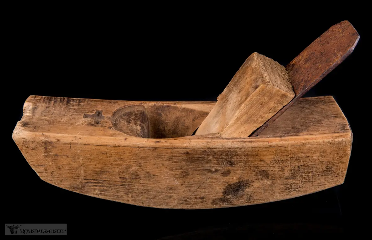 I forlengelse av sponhuset er det skåret ned i treet en halvsirkelform med et lite kors på toppen som minner om toppen på et kongelig rikseple.