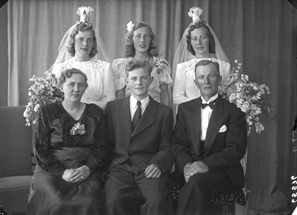 Gruppebilde. Familiegruppe på seks. To bruder, søstre, kvinne, mann og ung mann Bestilt av Einar Svanberg, Ole Ingvald Nøkling, Herr Kolstø.