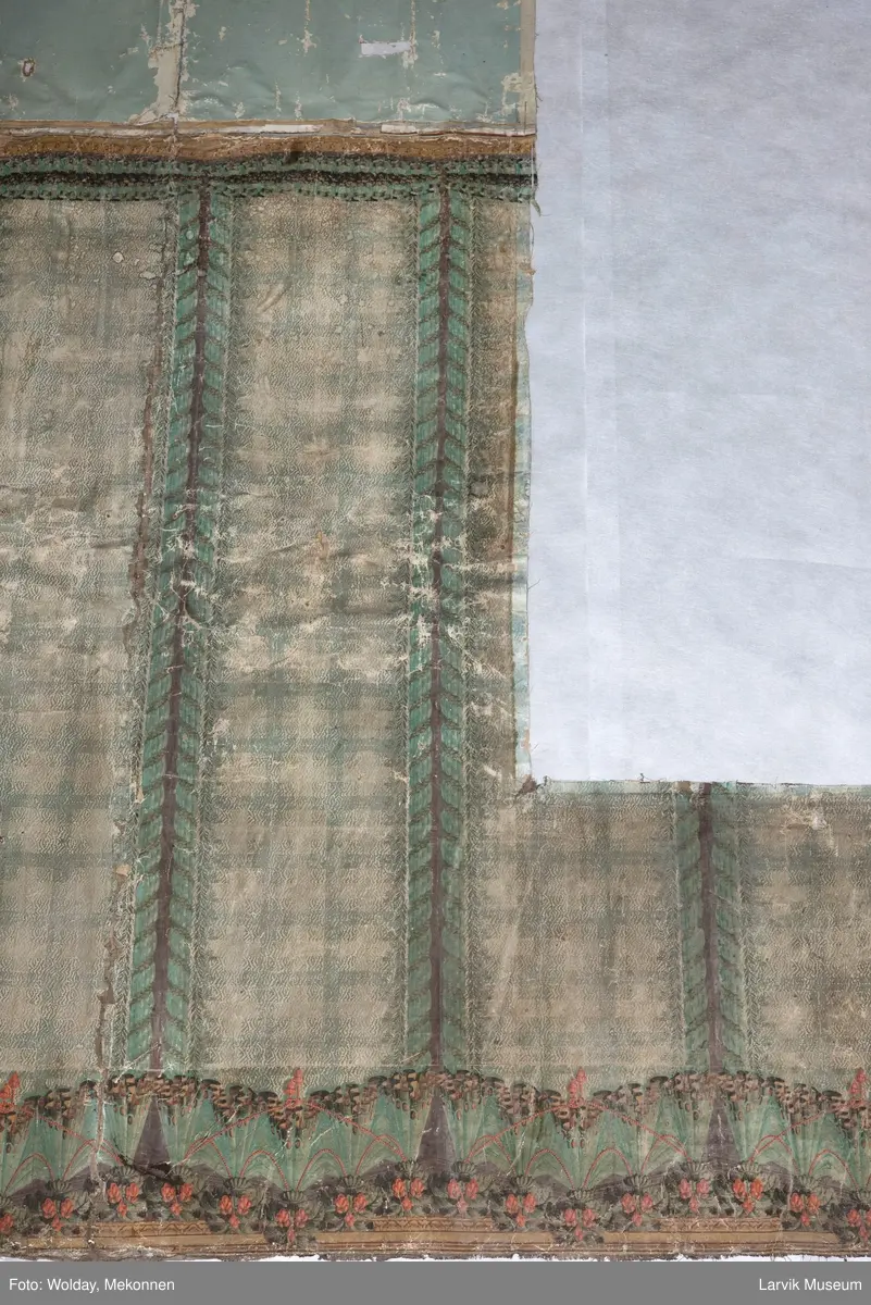 |Tapeten er påmalt tapetborder og brystning. Fra Hovland gård i Larvik.
Den øverste, brede borden: Gerlander/draperi med blomsterranker.
Den nederste, smalere borden: Tekstilbord med blomster. Øver døren til høyre: Stillebenmotiv med blomster og frukt.