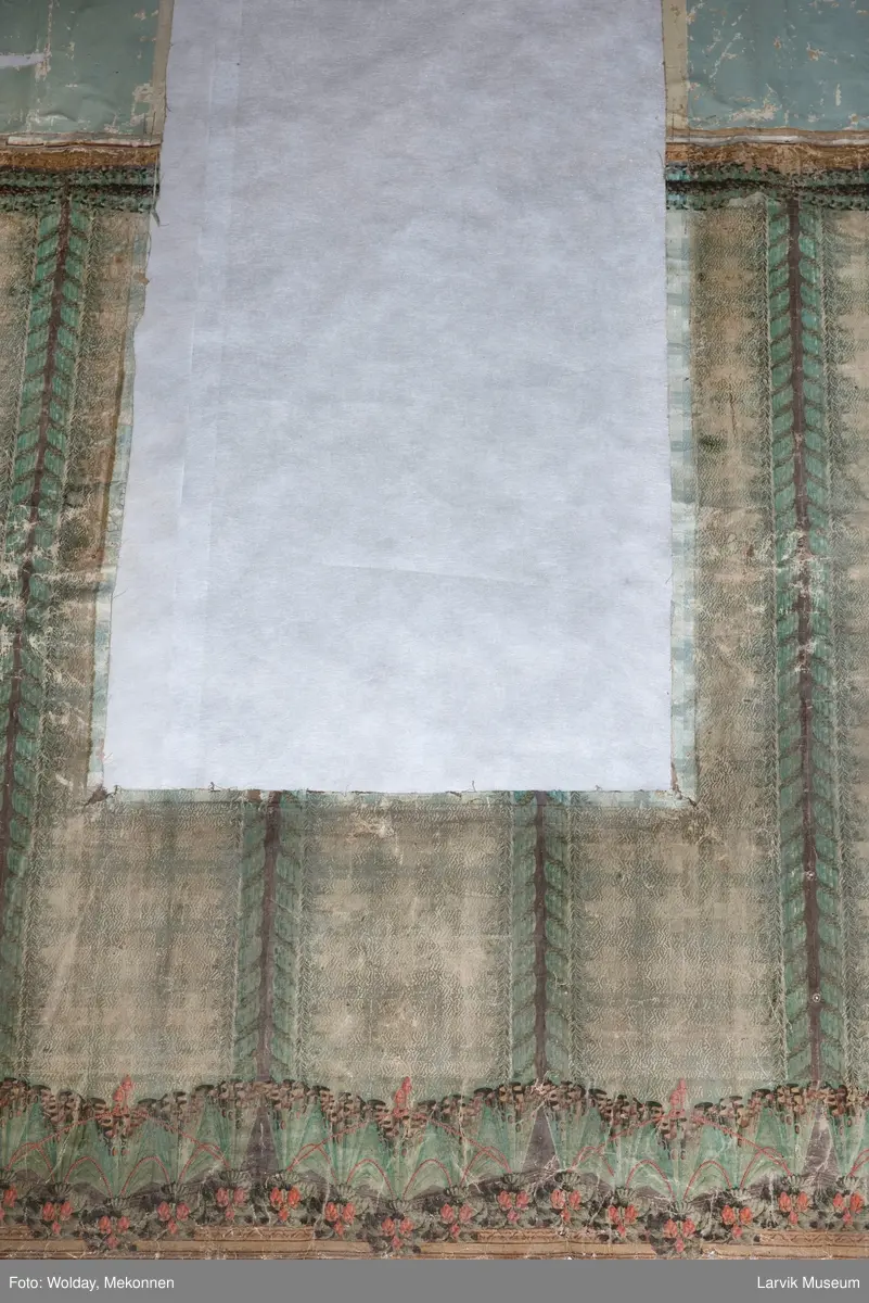 |Tapeten er påmalt tapetborder og brystning. Fra Hovland gård i Larvik.
Den øverste, brede borden: Gerlander/draperi med blomsterranker.
Den nederste, smalere borden: Tekstilbord med blomster. Øver døren til høyre: Stillebenmotiv med blomster og frukt.