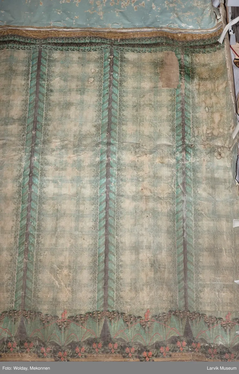 |Tapeten er påmalt tapetborder og brystning. Fra Hovland gård i Larvik.
Den øverste, brede borden: Gerlander/draperi med blomsterranker.
Den nederste, smalere borden: Tekstilbord med blomster. Øver døren til høyre: Stillebenmotiv med blomster og frukt.