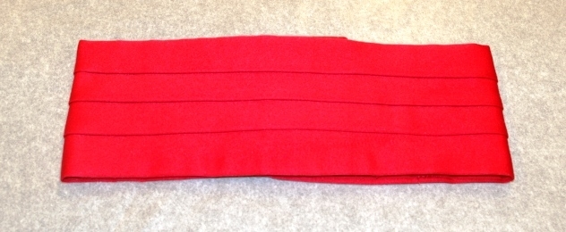 Jakke (a): blå polyester med for av blå kunstsilke. Rød krage og slag. 3 blanke knapper. Lyremotiv. Epauletter på skuldrene: rød, flettet silkesnor med blank knapp. Rød silkesnor rundt høyre skulder. Påsydde merker: norsk flagg, Mjøsegnenes krets, Gjøvik; Vindingstad skolekorps med logo
Bukse (b): blå polyester, røde render i sidesømmene. Nylon glidelås i gylfen. 1 blå plastknapp
Magebelte (c), rødt, blankt kunstfiberstoff, foret med rød bomull. 3 folder midt på. Lukkes med borrelås. 75 l, 12 b
Pyntesløyfe (d), samme tøy som beltet. Røde frynser i nedkant. Kan festes med borrelås til belte.  41 l, 12 b.