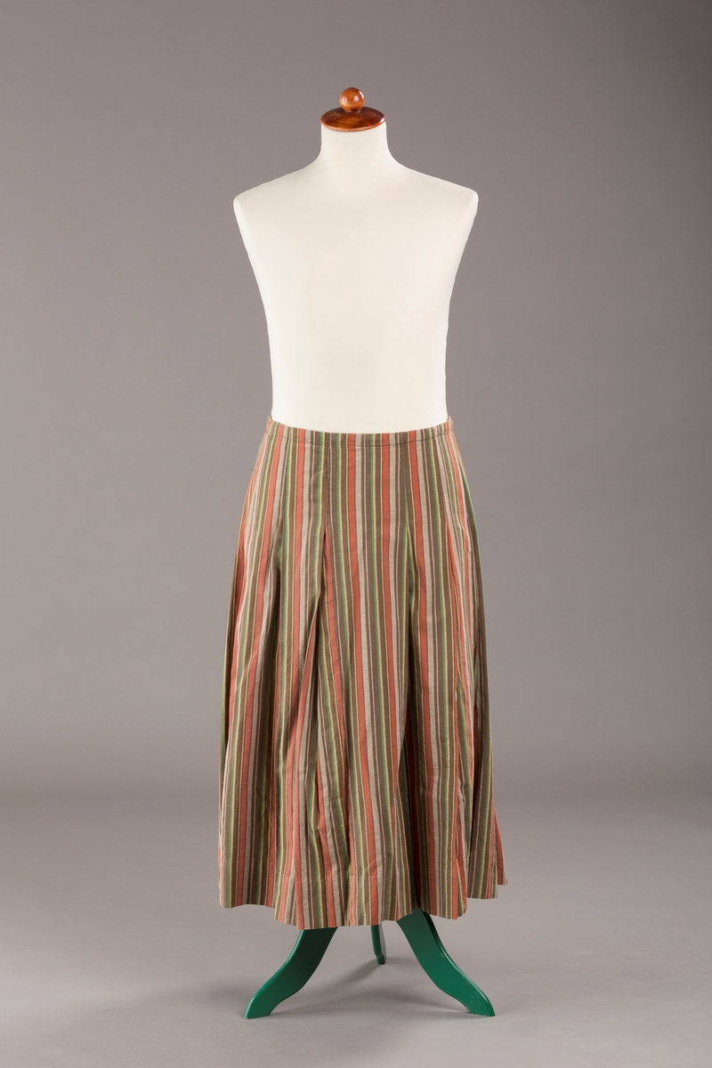 Stripete bomullsskjørt med nedsydde legg, uten linning, lukkes med trykknapper.