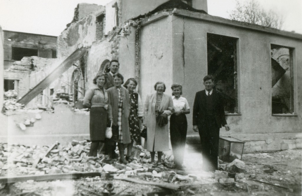 Ruiner av Narvik Sparebank, muligens med en del av personalet foran. Mannen bakerst er Hans Bjerke som jobbet i banken.