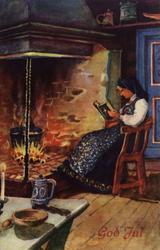 Julekort. Ubrukt. Interiør. Kvinne sitter ved peisen og lese