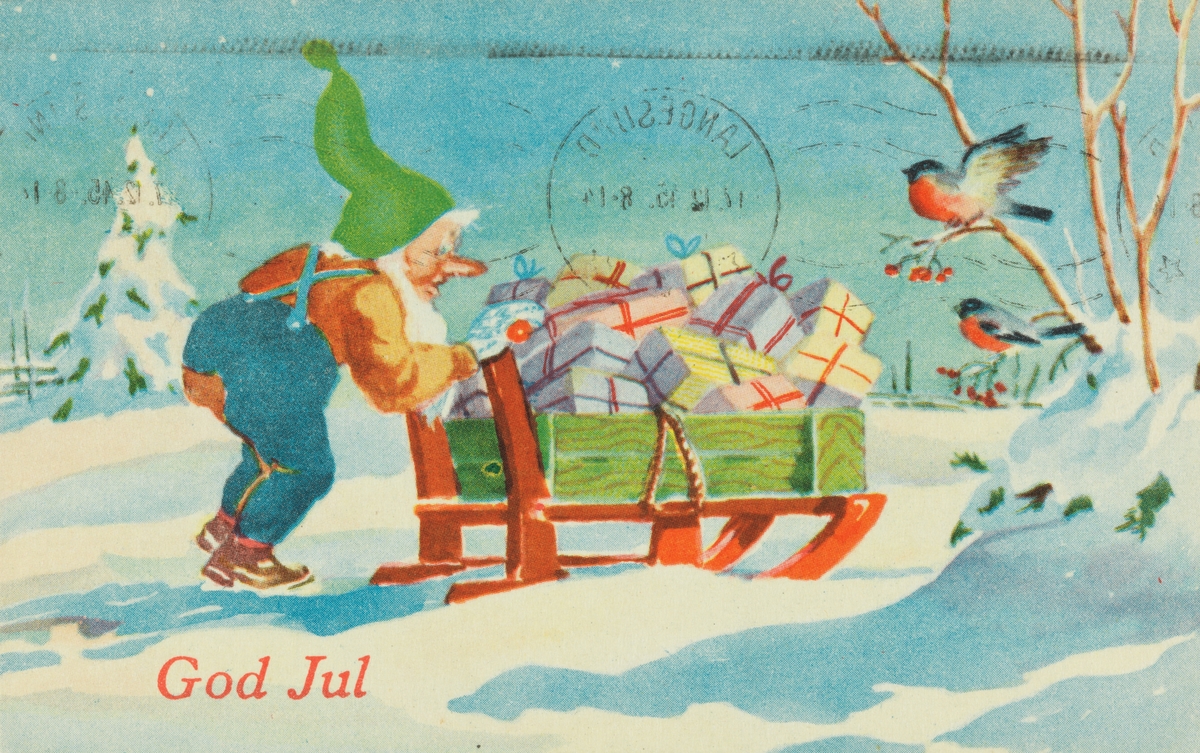 Julekort. Jule-og nyttårshilsen. Vintermotiv. En nisse med grønn topplue skyver på en kjelke full av julegaver. To dompapper er tilskuere. Stemplet 17.12.1945.
