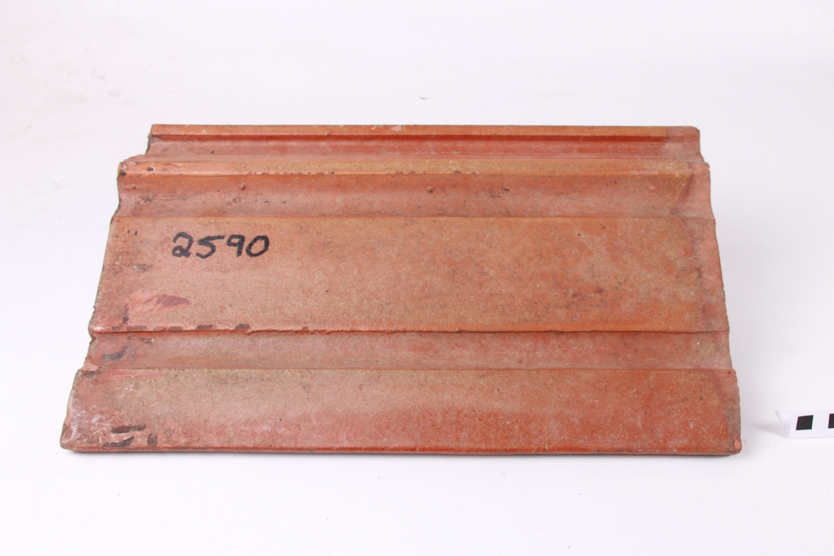 Dobbeltfalsa, pressa takpanne. Den er engrobert (halvglassert).