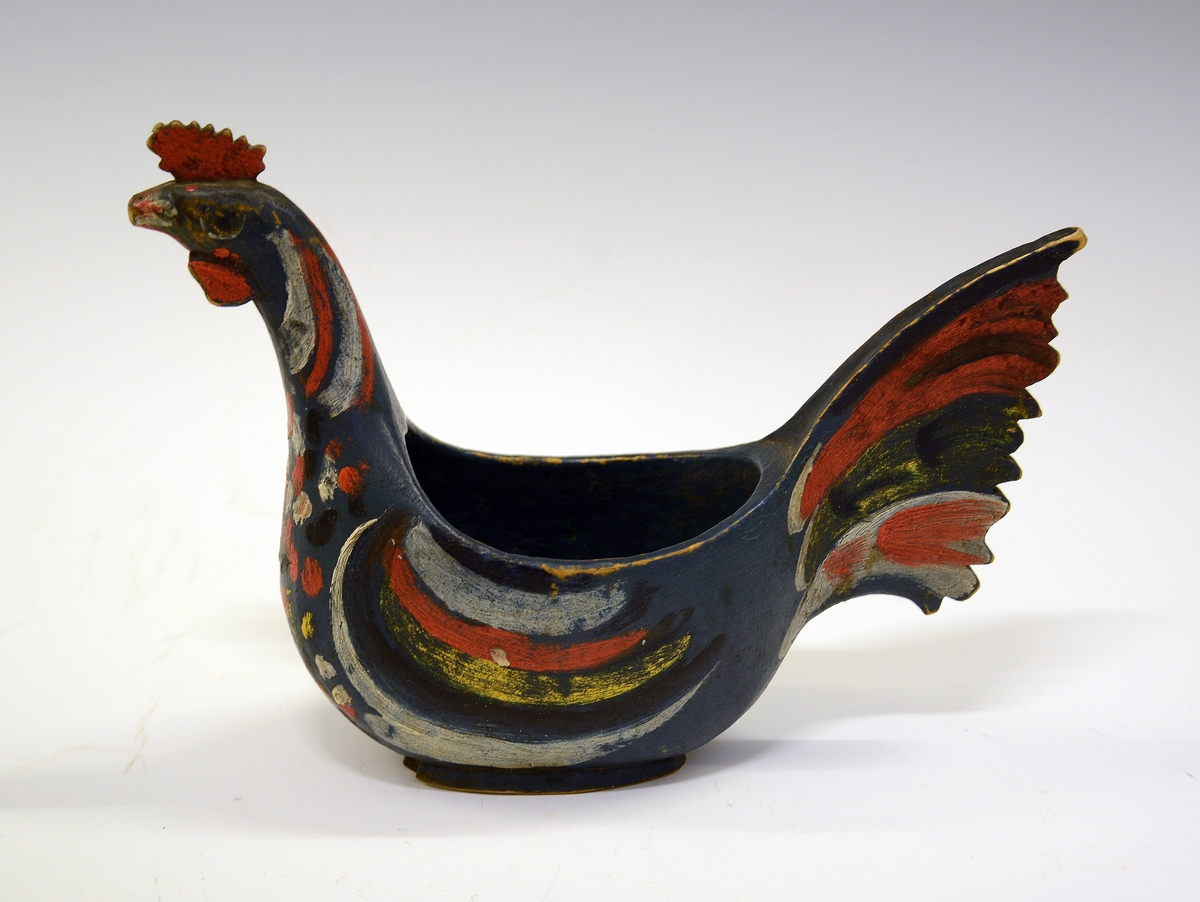 Ølhane. Fra protokollen: Eiskildskop i form av en hane; malt blaa med brogede fjær.