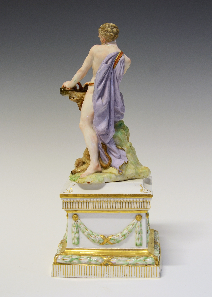 Herkules slåss mot en løve med bare hendene. Hans atributt, klubben ligger ved hans føtter, delvis under løven. De står på en underlag som imiterer gress. Under dette en kvadratisk sokkel med laurbærgirlandere i nyklassisistisk utførelse.