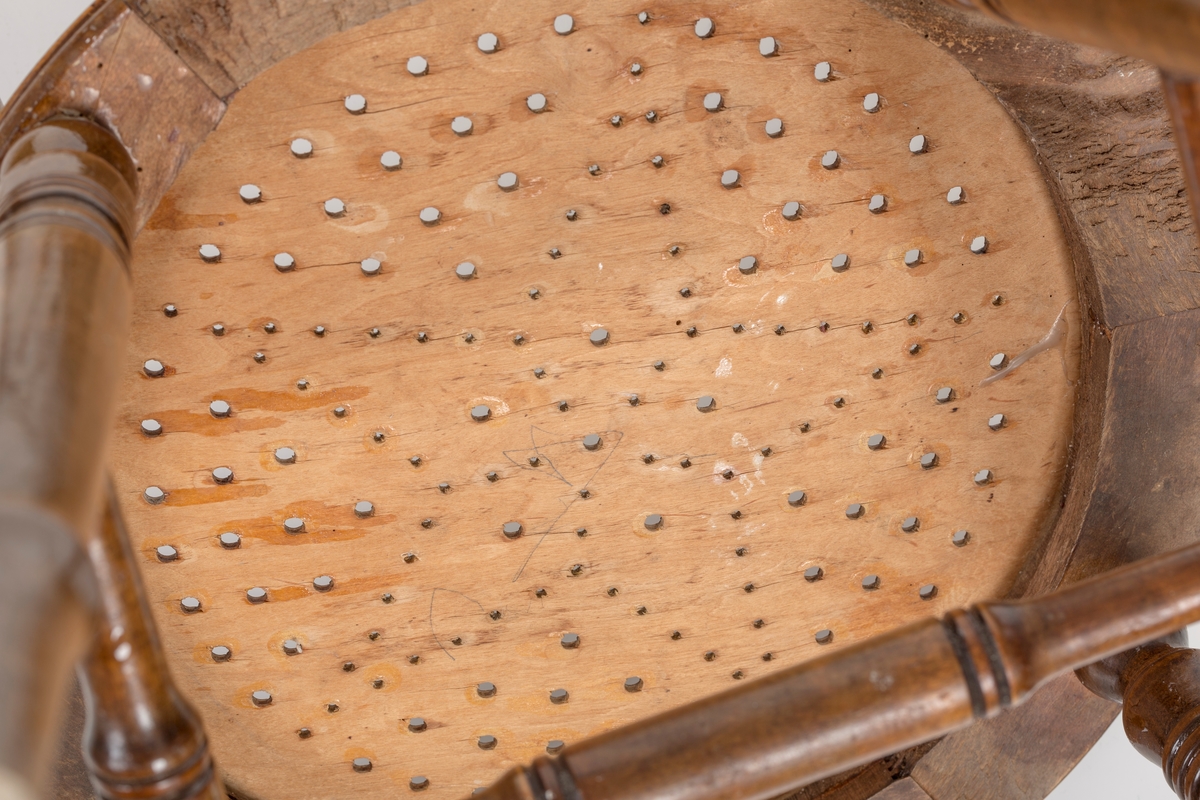 Stol i lakket treverk. Rundt stolsete med hullemønster. Rygg som er svakt buet med spiler og mønster. Dreide ben og spiler i rygg.