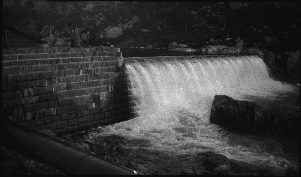 Noen gutter står ved en demning i nærheten av Jørpeland og Dalen og bilder fra et sted i nærheten av Småsilkomplekset, muligens fra Dalen. Småsilhornet og Heiahornet ruver opp i bakgrunnen.