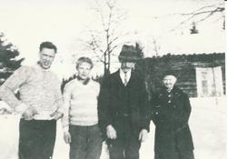 4 personer står utenfor en gammel stue.