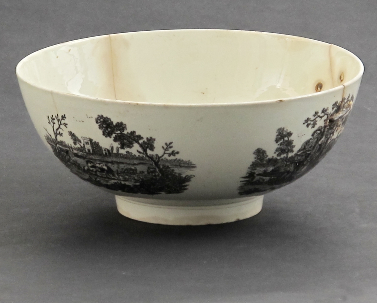 rundt siden 4 bonderomantiske landskaper: Gjeter og budeie  m. ku, Ku, der drikker i et vann; båt, vann og vind mølle;  Bonde der vasser over vann mot bondegård med sine to kuer; Beitende ku m. kalv, spaserende personer,  samt flod og hus i  bakgrunnen; innvendig i bunnen den  forelskede budeie  med sin gjeter i noe forstørret målestokk;